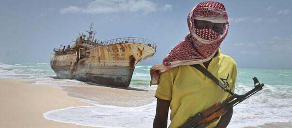 In this Sunday, Sept. 23, 2012 file photo, masked Somali pirate Hassan stands near a Taiwanese fishing vessel that washed up on shore after the pirates were paid a ransom and released the crew, in the once-bustling pirate den of Hobyo, Somalia. - Sputnik International