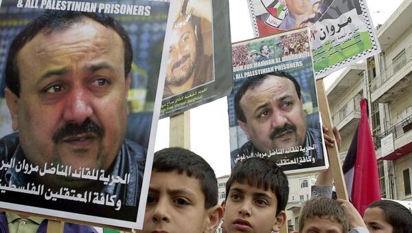 Palestinian youths hold pictures of Palestinian uprising leader Marwan Barghouti, detained in Israel, during a prisoners rally in the West Bank town of Ramallah Tuesday, April 15, 2003. - Sputnik International