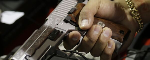 A customer looks at a SIG Sauer hand gun at a gun show held by Florida Gun Shows, Saturday, Jan. 9, 2016, in Miami. A customer looks at a SIG Sauer hand gun at a gun show held by Florida Gun Shows, Saturday, Jan. 9, 2016, in Miami. - Sputnik International