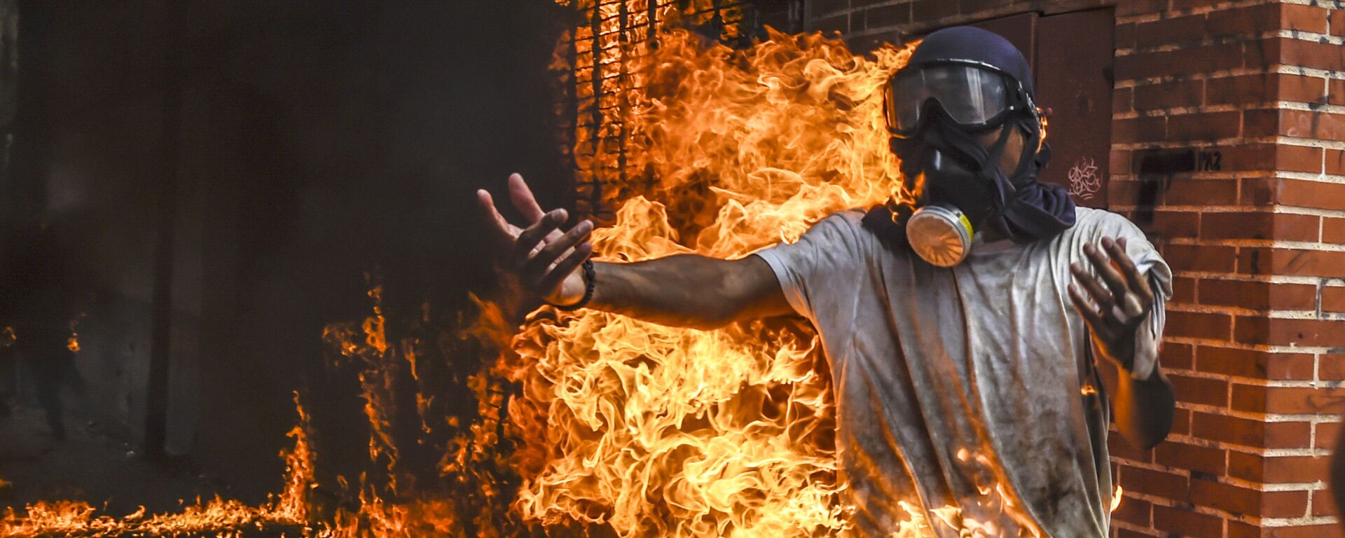 Демонстрант, охваченный огнем от взрыва бензобака мотоцикла, во время протестов в Венесуэле - Sputnik International, 1920, 25.11.2022