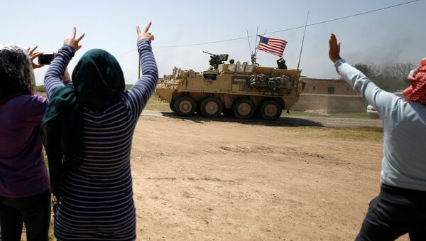 People gesture at a U.S military vehicle travelling in Amuda province, northern Syria April 29, 2017 - Sputnik International