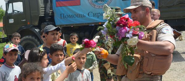 Children in the village of Brabishbo, Syria greet Russian servicemen with flowers and citrus fruit - Sputnik International
