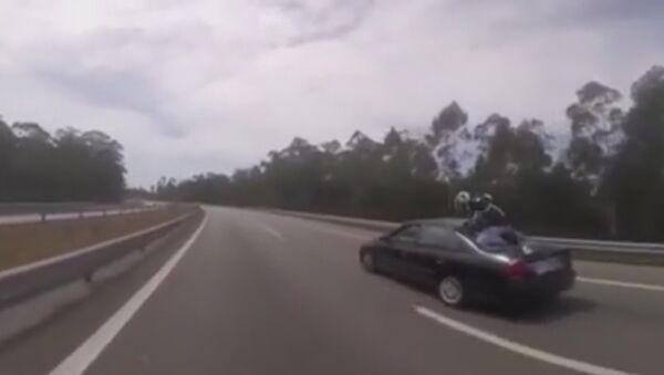 Biker cheats death as he comes off his bike and lands on back of car - Sputnik International