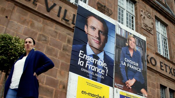 A woman walks near election campaign posters for French centrist presidential candidate Emmanuel Macron, left, and far-right candidate Marine Le Pen, in Saint Jean Pied de Port, southwestern France, Friday May 5, 2017 - Sputnik International
