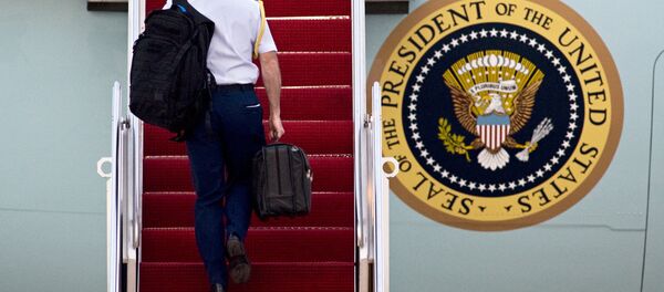 A Military aide carries 'the football', the leather briefcase stocked with the classified nuclear war plan, in his right hand as he walks up the stairs of Air Force One at Andrews Air Force Base, in Md. A Military aide carries 'the football', the leather briefcase stocked with the classified nuclear war plan, in his right hand as he walks up the stairs of Air Force One at Andrews Air Force Base, in Md. - Sputnik International