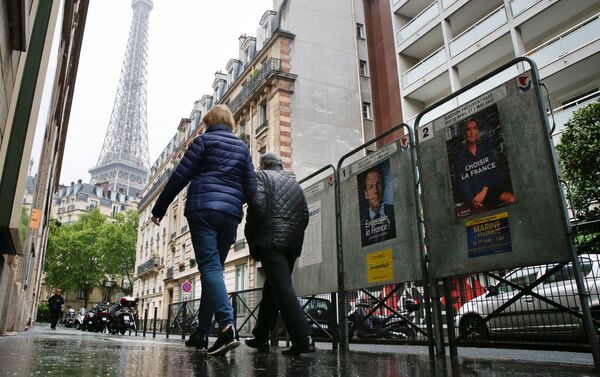 People pass election posters in Paris during the second round of 2017 French presidential election, France, May 7, 2017. - Sputnik International