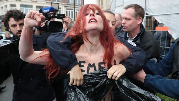 Police cover the chest of a member of feminist activist group Femen as they arrest her after unveiling a banner on a church in Henin-Beaumont, north-western France, to protest against French presidential election candidate for the far-right Front National (FN - National Front) party Marine Le Pen on May 7, 2017, during the second round of the Presidential election. - Sputnik International