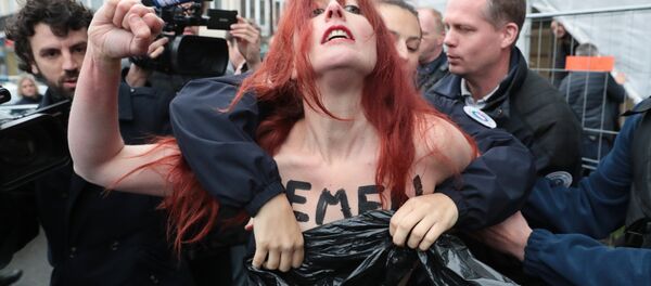 Police cover the chest of a member of feminist activist group Femen as they arrest her after unveiling a banner on a church in Henin-Beaumont, north-western France, to protest against French presidential election candidate for the far-right Front National (FN - National Front) party Marine Le Pen on May 7, 2017, during the second round of the Presidential election. - Sputnik International