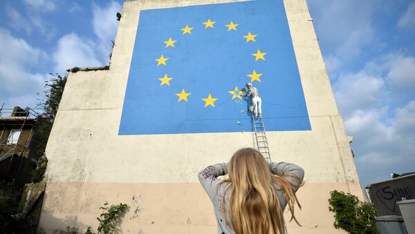 A young girl looks at artwork attributed to street artist Banksy, depicting a workman chipping away at one of the 12 stars on the European Union, seen on a wall in the ferry port of Dover, Britain, May 7, 2017. - Sputnik International