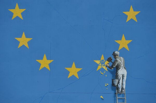 A section of an artwork attributed to street artist Banksy, depicting a workman chipping away at one of the 12 stars on the flag of the European Union, is seen on a wall in the ferry port of Dover. - Sputnik International