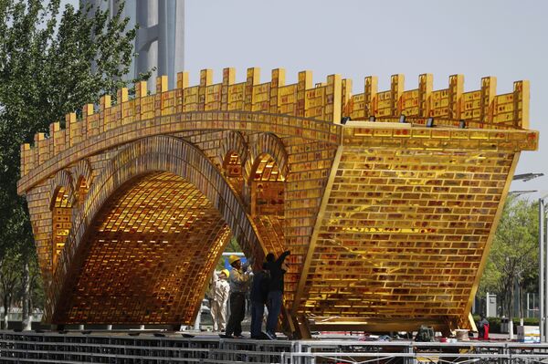 Workers install wires on a 'Golden Bridge of Silk Road' structure on a platform outside the National Convention Center, the venue which will hold the Belt and Road Forum for International Cooperation, in Beijing - Sputnik International