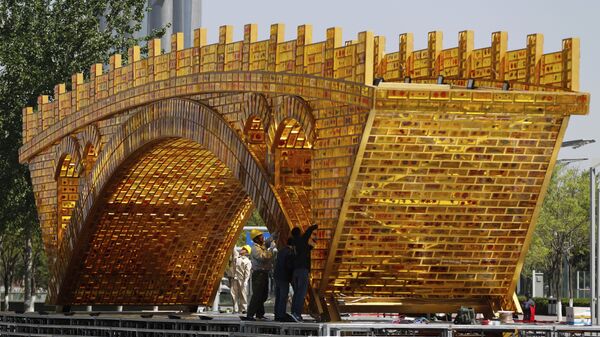 Workers install wires on a 'Golden Bridge of Silk Road' structure on a platform outside the National Convention Center, the venue which will hold the Belt and Road Forum for International Cooperation, in Beijing - Sputnik International