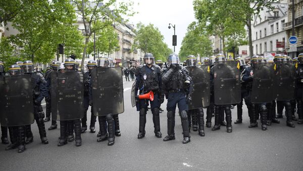 Riot police stands in a street while people take part in a demonstration called by the collectif Front Social and labour unions on May 8, 2017 a day after the French presidential election. - Sputnik International