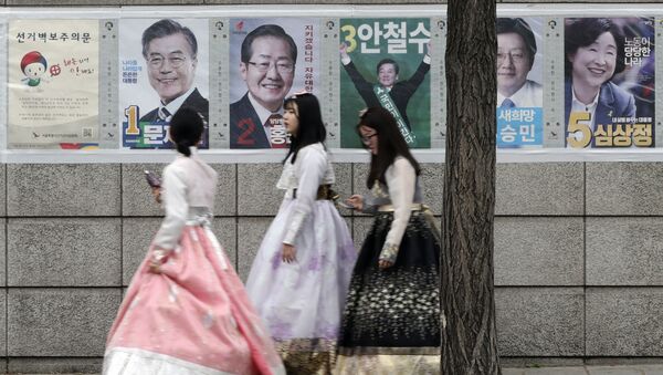 Women walk by posters showing candidates for the presidential election in Seoul, South Korea, Tuesday, May 9, 2017. - Sputnik International