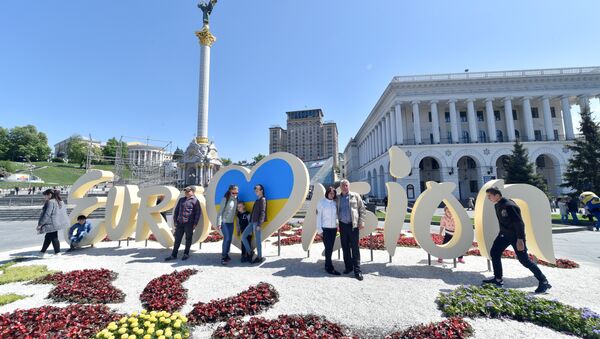 People pose for pictures in front of the official logo for the Eurovision Song Contest on Independence Square in Kiev on May 3, 2017. - Sputnik International