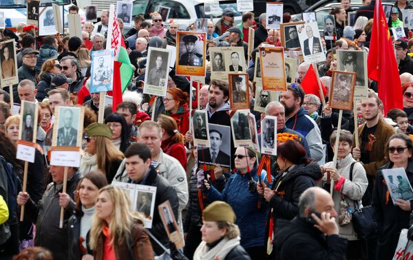 People carrying portraits of deceased relatives as they attend the Immortal Regiment march during the Victory Day celebrations at the Soviet War Memorial in Berlin, Germany - Sputnik International