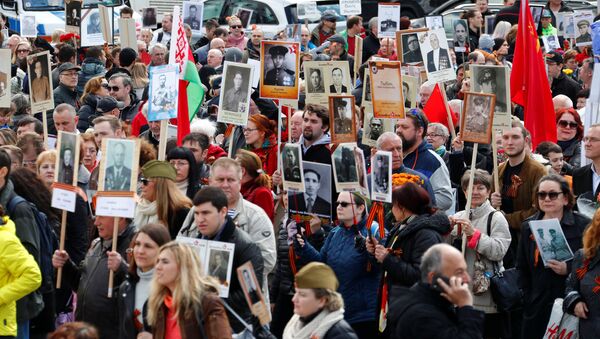 People carrying portraits of deceased relatives as they attend the Immortal Regiment march during the Victory Day celebrations at the Soviet War Memorial in Berlin, Germany - Sputnik International