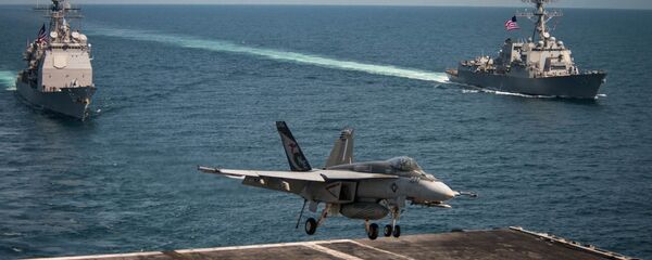 An F/A-18E Super Hornet lands on the flight deck of the U.S. Navy aircraft carrier USS Carl Vinson as the Ticonderoga-class guided-missile cruiser USS Lake Champlain (L) and the Arleigh Burke-class guided-missile destroyer USS Wayne E. Meyer transit the western Pacific Ocean May 3, 2017. - Sputnik International
