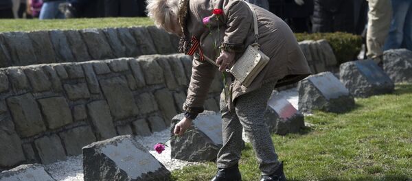 A woman lays a flower put flowers at the WWII memorial for Soviet soldiers, called the Slavin in Bratislava. (File) - Sputnik International