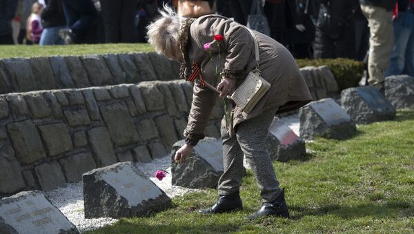A woman lays a flower put flowers at the WWII memorial for Soviet soldiers, called the Slavin in Bratislava. (File) - Sputnik International