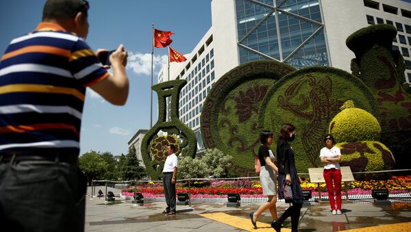 A man takes pictures of a flower display set up ahead of the Belt and Road Forum in central Beijing, China, May 10, 2017 - Sputnik International