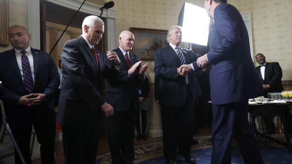 Vice President Mike Pence, second from left, and Secret Service Director Joseph Clancy stand as President Donald Trump shakes hands with FBI Director James Comey during a reception for inaugural law enforcement officers and first responders in the Blue Room of the White House, 22 January 2017 in Washington - Sputnik International