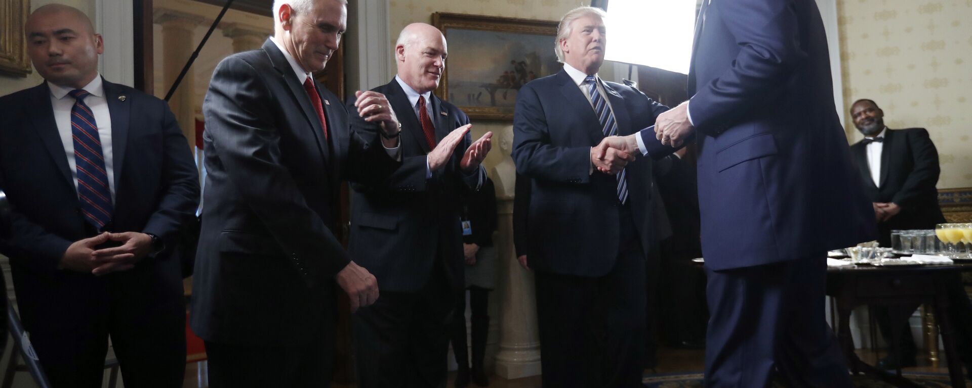 Vice President Mike Pence, second from left, and Secret Service Director Joseph Clancy stand as President Donald Trump shakes hands with FBI Director James Comey during a reception for inaugural law enforcement officers and first responders in the Blue Room of the White House, Sunday, Jan. 22, 2017 in Washington - Sputnik International, 1920, 01.12.2021