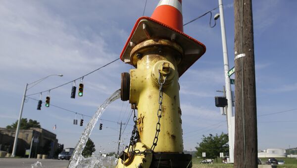 A road pylon caps the top of a fire hydrant being serviced, Thursday, June 26, 2014, in Cincinnati. - Sputnik International