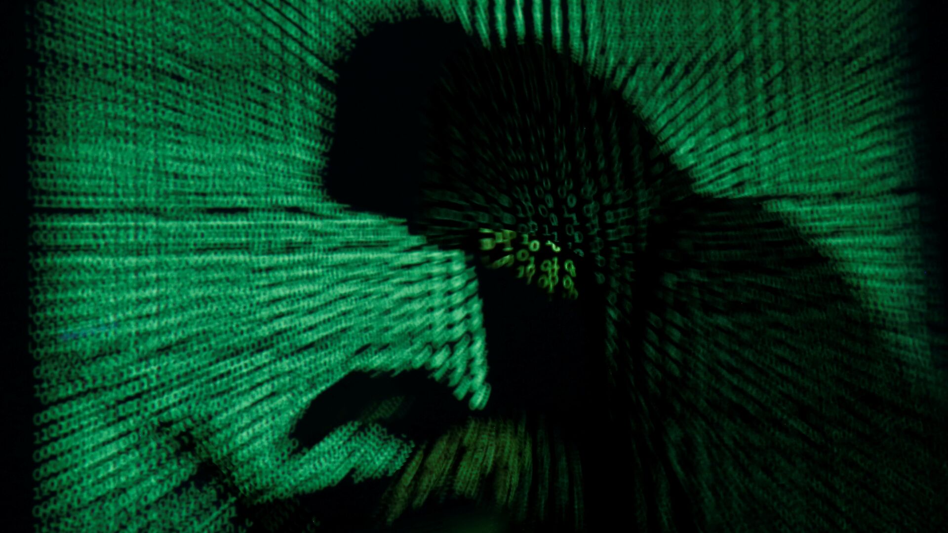 A hooded man holds a laptop computer as cyber code is projected on him in this illustration picture taken on May 13, 2017 - Sputnik International, 1920, 14.03.2022