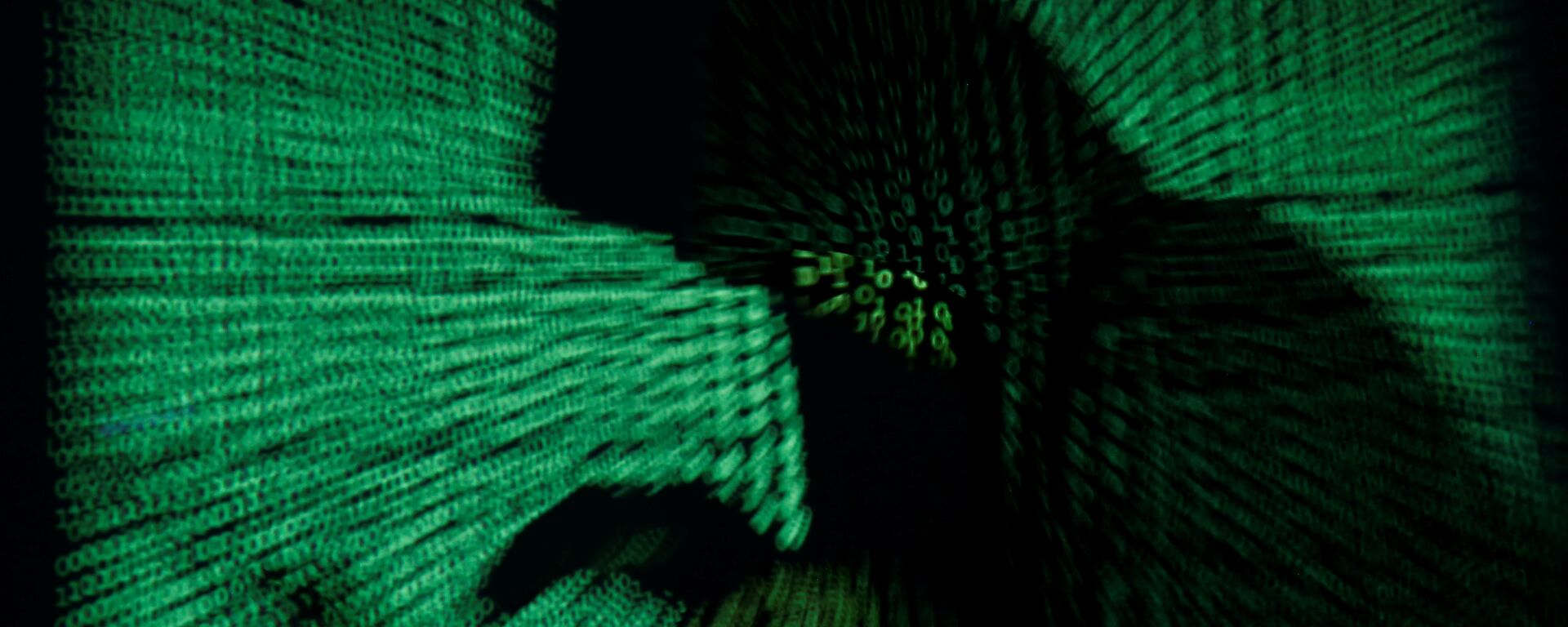 A hooded man holds a laptop computer as cyber code is projected on him in this illustration picture taken on May 13, 2017 - Sputnik International, 1920, 20.07.2021