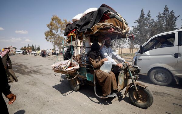 Internally displaced people who fled Raqqa city ride a tricycle with their belongings as they leave a camp in Ain Issa, Raqqa Governorate, Syria May 4, 2017 - Sputnik International