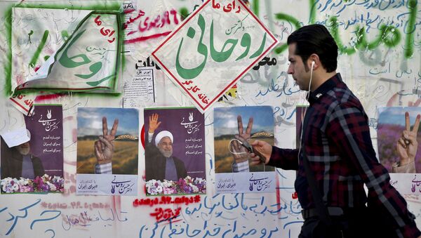 In this Wednesday, May 10, 2017 photo, an Iranian man walks past electoral posters and hand written slogans for presidential election candidates in downtown Tehran, Iran - Sputnik International