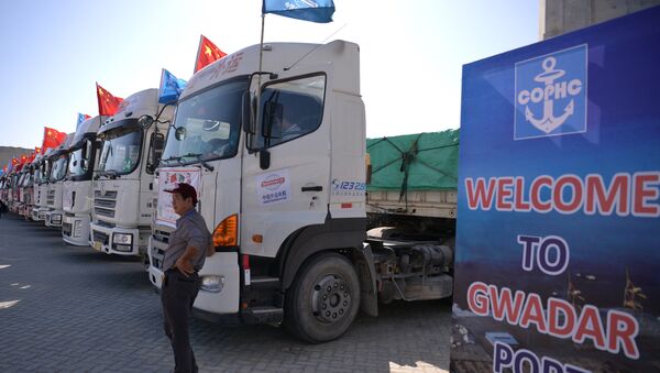 A Chinese worker stands near trucks carrying goods during the opening of a trade project in Gwadar port, some 700 kms west of the Pakistani city of Karachi on November 13, 2016. - Sputnik International