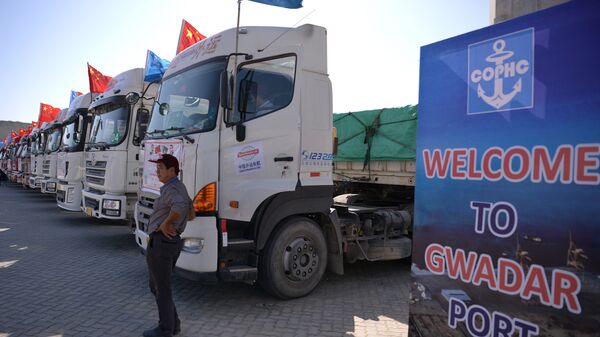 A Chinese worker stands near trucks carrying goods during the opening of a trade project in Gwadar port, some 700 kms west of the Pakistani city of Karachi on November 13, 2016. - Sputnik International