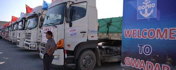 A Chinese worker stands near trucks carrying goods during the opening of a trade project in Gwadar port, some 700 kms west of the Pakistani city of Karachi on November 13, 2016. - Sputnik International
