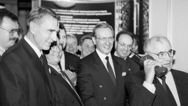 Then-Finnish President Mauno Koivisto (L) looks on as then-Soviet President Mikhail Gorbachev talks to Moscow on a Nokia Mobira Cityman cellular phone in Helsinki on October 26, 1989 - Sputnik International
