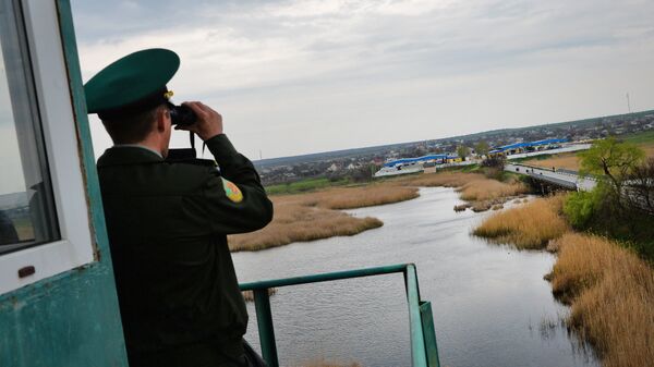 A transdniestr border police officer from separatist region of Moldova looks at Ukraine border point at Kuchurgan-Pervomaysk, Ukraine-Moldova border point on April 15, 2014. - Sputnik International
