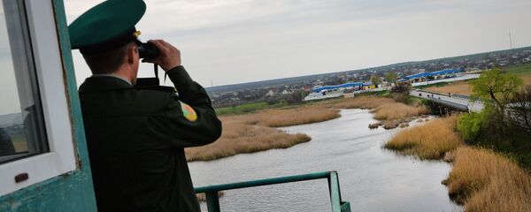 A transdniestr border police officer from separatist region of Moldova looks at Ukraine border point at Kuchurgan-Pervomaysk, Ukraine-Moldova border point on April 15, 2014. A transdniestr border police officer from separatist region of Moldova looks at Ukraine border point at Kuchurgan-Pervomaysk, Ukraine-Moldova border point on April 15, 2014. - Sputnik International