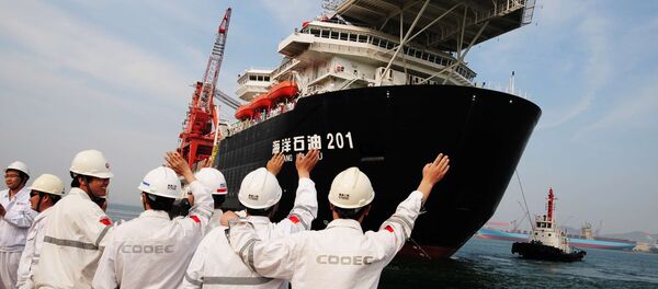 Chinese port workers wave as China National Offshore Oil Corp. (CNOOC)'s first independent deep-water oil drilling rig, was sent off from the port of Qingdao, east China's Shandong province. China's first home-grown deep-water drilling rig will be located in the South China Sea, some 300 kilometres (200 miles) southeast of Hong Kong Chinese port workers wave as China National Offshore Oil Corp. (CNOOC)'s first independent deep-water oil drilling rig, was sent off from the port of Qingdao, east China's Shandong province. China's first home-grown deep-water drilling rig will be located in the South China Sea, some 300 kilometres (200 miles) southeast of Hong Kong - Sputnik International
