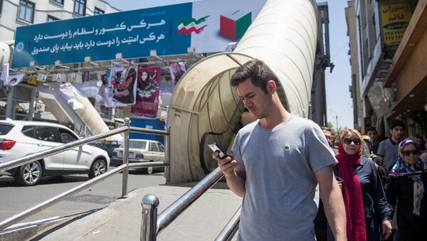 A man uses his smartphone to follow election news in Tehran, Iran May 17, 2017 - Sputnik International
