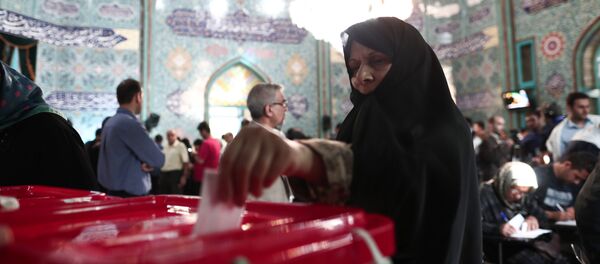 An Iranian woman casts her ballot for the presidential elections at a polling station in Tehran on May 19, 2017 - Sputnik International