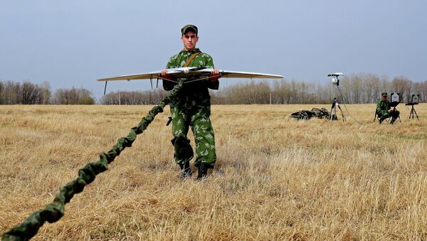 A serviceman of the reconnaissance unit of an Eastern Military District motorized rifle formation launches a drone during special tactical training at the Anastasyevsky base in the Khabarovsk Territory - Sputnik International