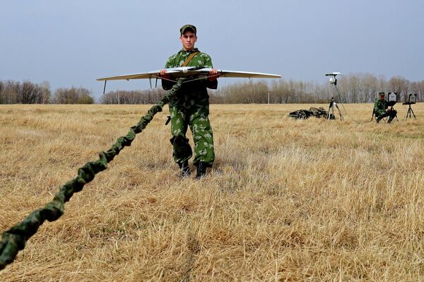 A serviceman of the reconnaissance unit of an Eastern Military District motorized rifle formation launches a drone during special tactical training at the Anastasyevsky base in the Khabarovsk Territory - Sputnik International