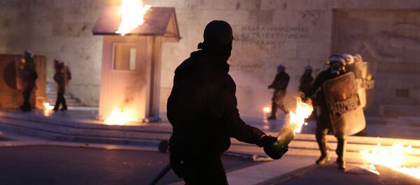 A masked demonstrator prepares to throw a petrol bomb to riot police outside the parliament building as Greek lawmakers vote on the latest round of austerity Greece has agreed with its lenders, in Athens, Greece, May 18, 2017. A masked demonstrator prepares to throw a petrol bomb to riot police outside the parliament building as Greek lawmakers vote on the latest round of austerity Greece has agreed with its lenders, in Athens, Greece, May 18, 2017. - Sputnik International