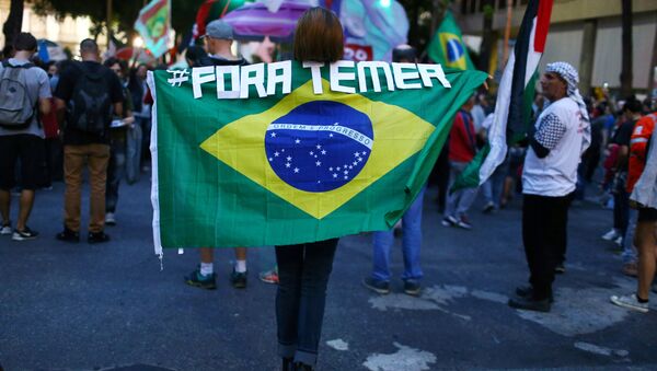 A demonstrator carries a Brazilian national flag as she attends a protest against Brazil's President Michel Temer in Rio de Janeiro, Brazil, May 18, 2017 - Sputnik International