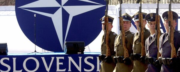 Members of a honor guard present arms in front of the NATO logo during a ceremony to mark the country's entry into the military alliance. File photo - Sputnik International