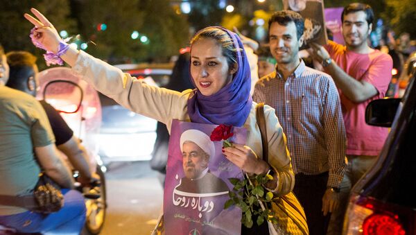 A woman holds a poster of Iranian President Hassan Rouhani during a campaign rally in Tehran, Iran, May 17, 2017 - Sputnik International