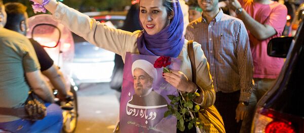A woman holds a poster of Iranian President Hassan Rouhani during a campaign rally in Tehran, Iran, May 17, 2017 - Sputnik International