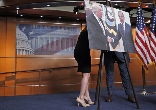 An aide, left, speaks with Rep. Joe Crowley, D-N.Y., chairman of the House Democratic Caucus, and House Oversight and Government Reform Committee ranking member, on Capitol Hill in Washington, Wednesday, May 17, 2017, behind a photograph of President Donald Trump and Russian Foreign Minister Sergey Lavrov, during a news conference - Sputnik International