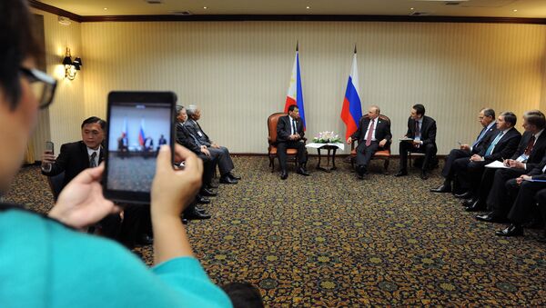 November 19, 2016. Russian President Vladimir Putin and Philippine President Rodrigo Duterte, background left, during a meeting on the sidelines of the APEC summit in Lima - Sputnik International